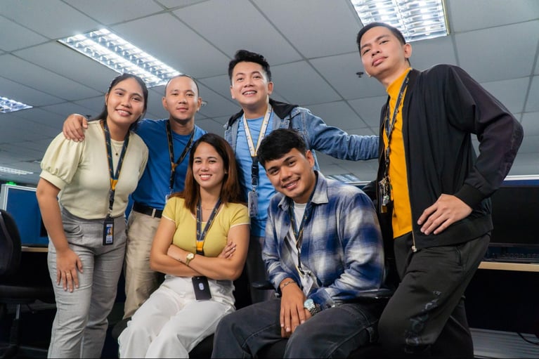 A group of call centre agents from Select VoiceCom pose for the camera in a Philippine call centre office.