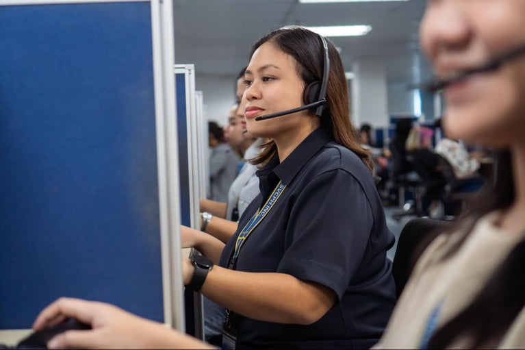A group of female call center agents from Select VoiceCom taking customer calls in the Philippine call center office.