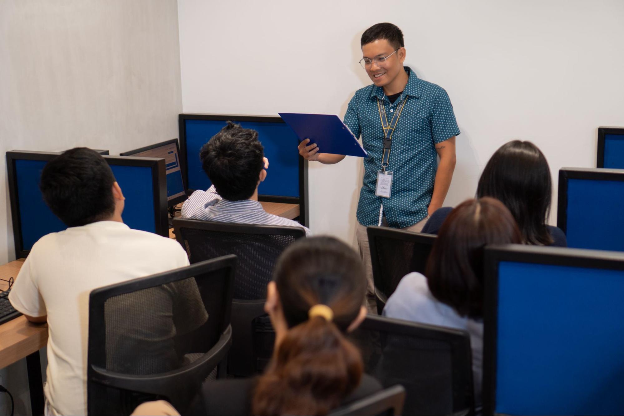 Select VoiceCom's customer service representatives during a discussion meeting inside a Philippine call centre office.