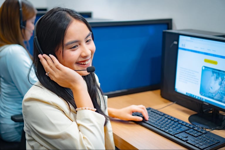 A female call center representative taking a customer call during her shift in a Philippine call center office.
