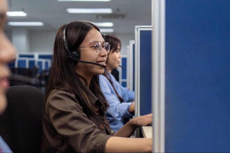 A group of female Select VoiceCom employees taking customer calls in a Philippine call center office.