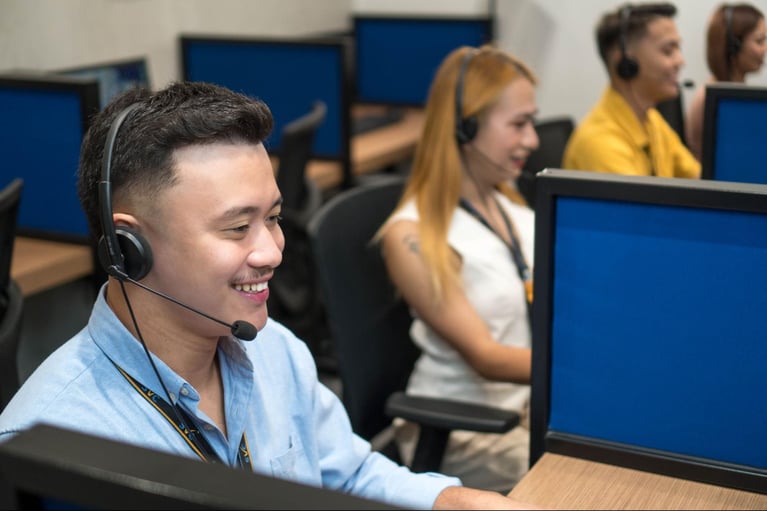 A group of call center agents handling customer calls inside Select VoiceCom's office.