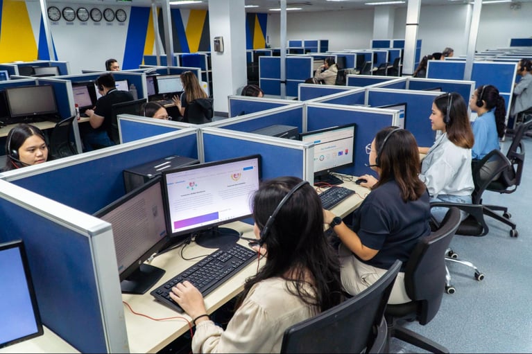 A group of call center employees from Select VoiceCom at work in a call center office in the Philippines.