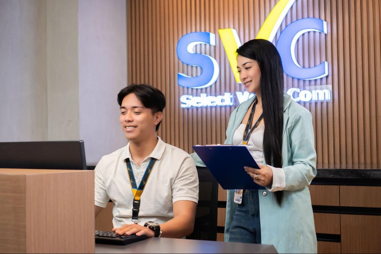 A female and male employees from Select VoiceCom during working hours in a Philippine call centre office.