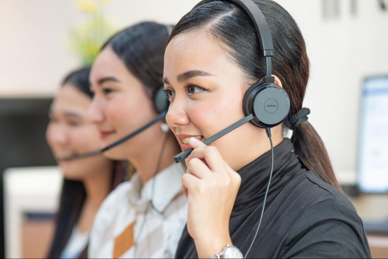 A group of female Select VoiceCom employees taking customer calls in a Philippine call centre office.