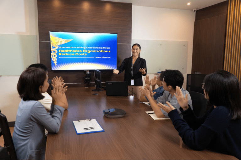 A group of Select VoiceCom employees engages in a discussion during a meeting at their Philippine call center office.