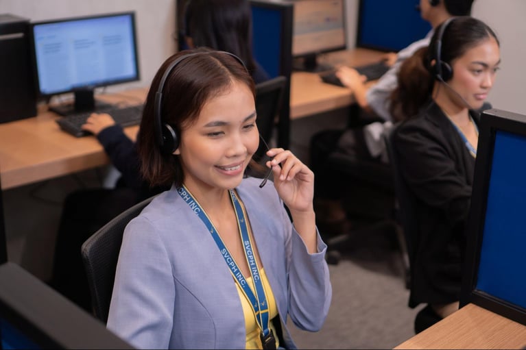 A group of female call center agents from Select VoiceCom taking customer calls in the Philippine call center office.
