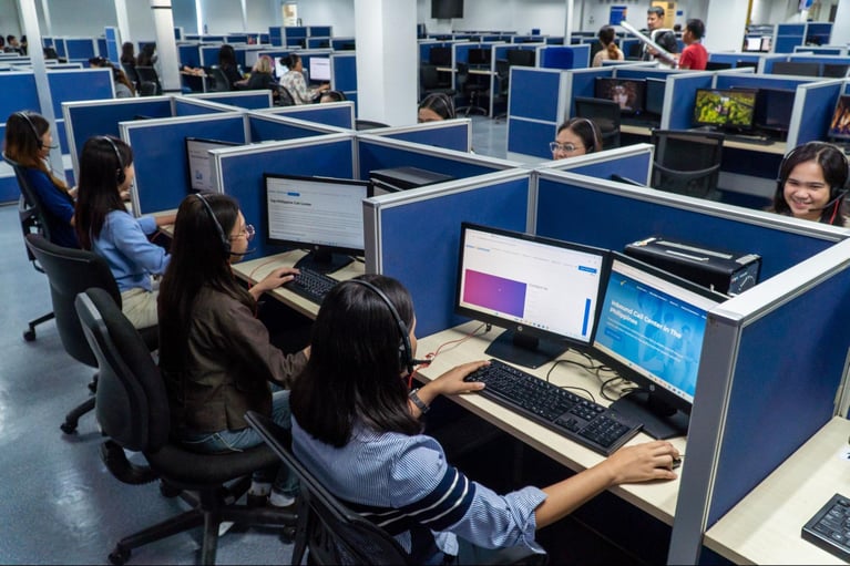 A group of call center employees from Select VoiceCom at work in a call center office in the Philippines.