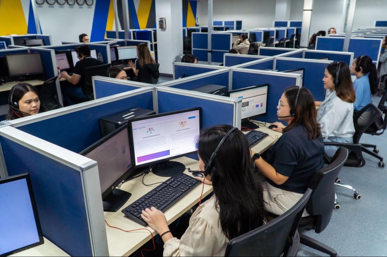 A group of call centre agents from Select VoiceCom taking customer calls in the Philippine call centre office.