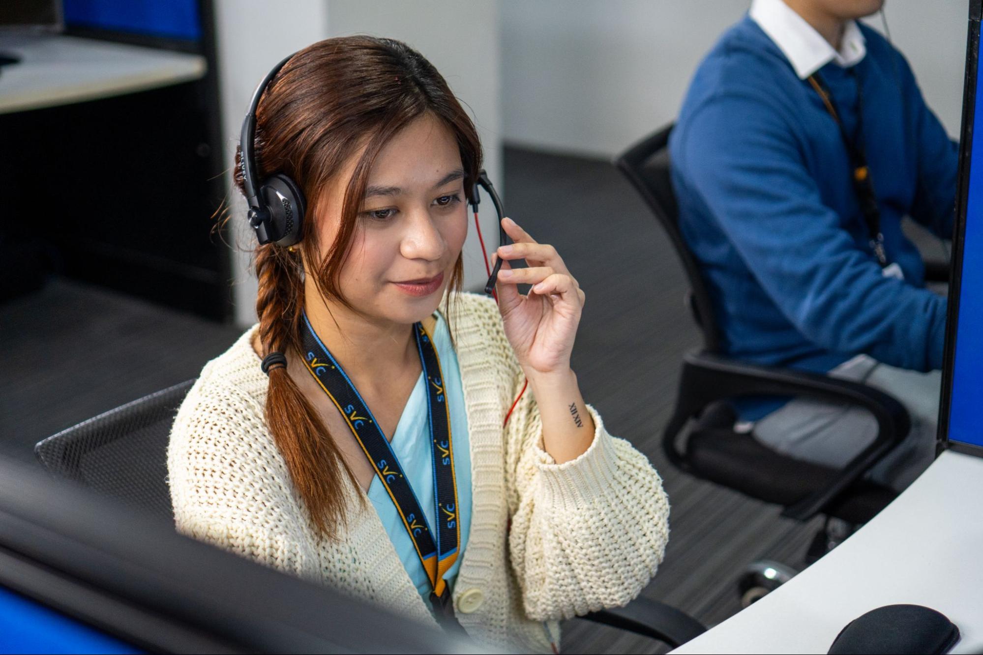 A Select VoiceCom female call center agent taking a call in a Philippine call center office.