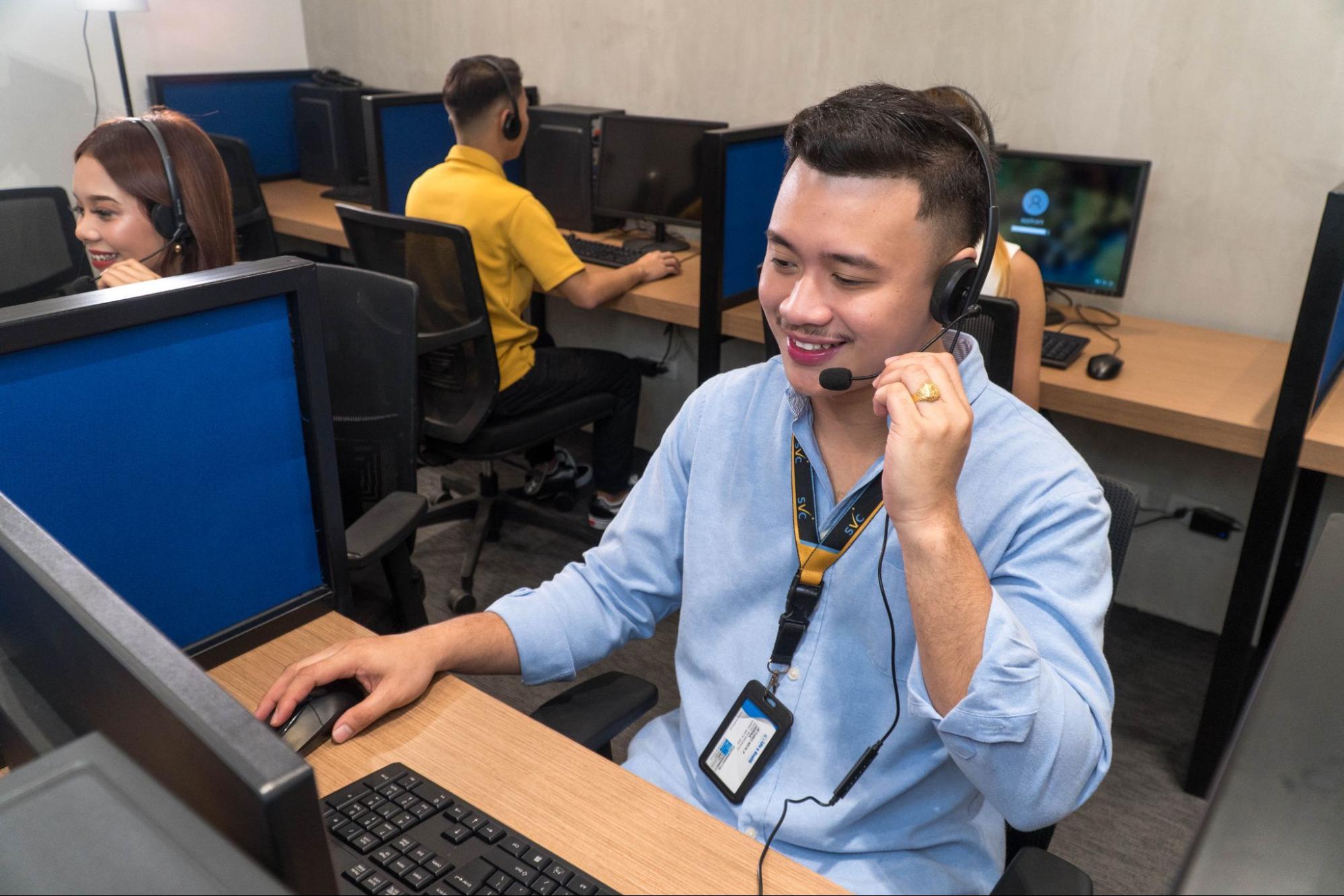 A group of customer service representatives catering to customer calls in a call center setting.