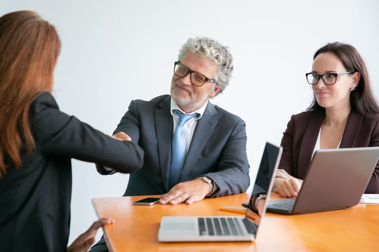 red-haired-businesswoman-greeting-bearded-colleague